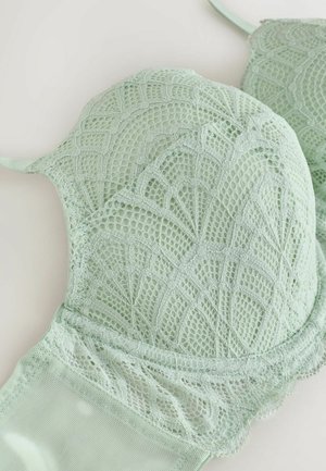 Light green lace bra with floral and geometric patterns, padded cups, and adjustable shoulder straps on a white background.