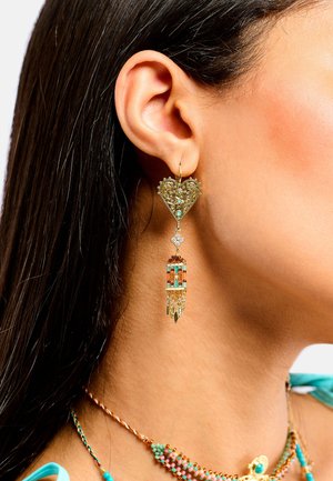 Boucles d'oreilles en forme de cœur en or ornées de filigrane complexe et d'accents turquoise, avec une touche de perles multicolores et une frange décorative.