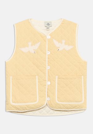 Prošiveni prsluk blijedo žute boje bez rukava s bijelim obrubima, prednjim džepovima, kopčanjem na gumbe i dva bijela pticina aplikacija blizu ramena.