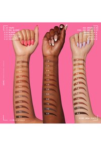 Trois bras présentent différentes teintes de crayon à sourcils sur un fond rose. Chaque bras affiche des échantillons étiquetés de 1,0 à 8,0, avec des tons de peau variés.