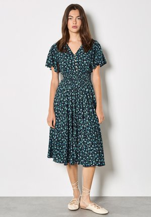 Sukienka w kwiaty z krótkimi, falbaniastymi rękawami, granatowym tłem i małymi turkusowymi kwiatami. Posiada zapięcie na guziki z przodu oraz elastyczną talię.