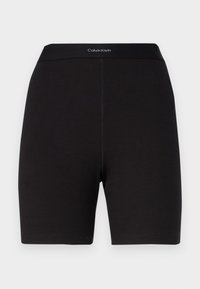 Svarta ribbade shorts med en åtsittande design och elastisk midja som har "Calvin Klein"-logotypen i vitt. Inga fickor eller distinkta mönster.