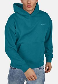 Sudadera turquesa de algodón, con un bolsillo frontal, puños de canalé y un corte casual. Logo "Jack & Jones" en el pecho.