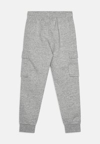Grå joggebukser laget av et mykt, struttende stoff. Har sidelommer, elastisk midje og smale mansjetter ved anklene.