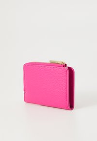 Fuchsia pink leather wallet with a textured surface, zip closure, and minimalistic design, featuring gold-tone hardware and compact shape.