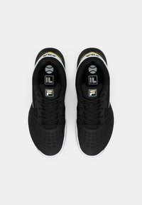 Sorte atletiske sko med mesh-overdel, tekstureret overflade, hvide og gyldne accenter samt et karakteristisk såledesign med Fila-logoet.