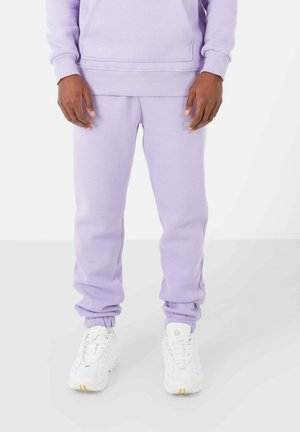 Lavender pullover hoodie met kangoeroezak en bijpassende lavendel joggers. Zachte stof, geribbelde manchetten en witte sneakers met gele accenten.