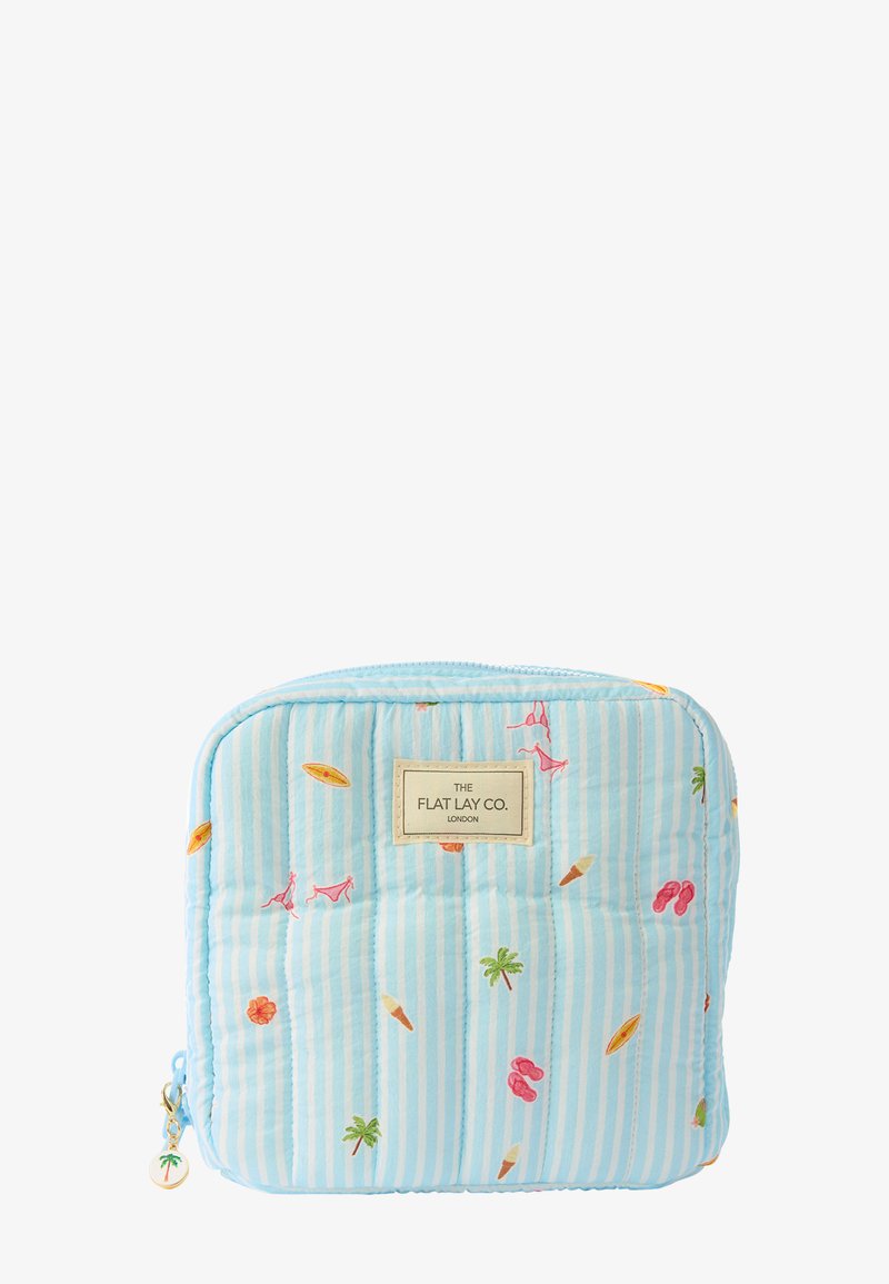 Pochette matelassée bleu clair avec des rayures blanches, décorée de petites icônes estivales comme des palmiers, des glaces, des tongs, des planches de surf, et une étiquette portant l'inscription "The Flat Lay Co."
