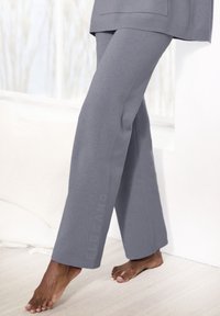 Pilki medvilniniai laisvalaikio kelnių su laisvu pjūviu, tiesia forma ir minkšta tekstūra, su diskretišku prekės ženklo ženklinimu šone.