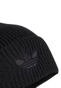 Beanie nera lavorata a maglia con texture a coste, caratterizzata da un discreto logo scuro sulla parte anteriore. Il tessuto appare caldo e flessibile.