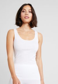 Witte tanktop met een ronde hals, brede schouderbanden en een getailleerde pasvorm, gemaakt van een gladde, rekbare katoenmix.