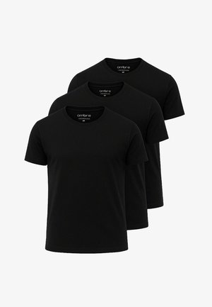 Tre magliette di cotone nere con maniche corte, design a girocollo, texture liscia e senza motivi o grafiche visibili.