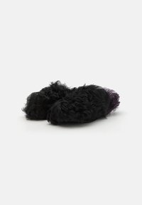 Svarta fluffiga tofflor med ett texturerat, lockigt material och en plysch-lila detalj baktill, med en rundad form för komfort.