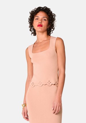 Lichtroze mouwloos topje met een vierkante halslijn, met een scalloped zoom en bloemvormige uitsnijdingen, gemaakt van zachte stof.