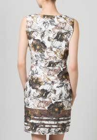 Vestido floral de verano con silueta ajustada, que presenta una base blanca, patrones de flores marrones y negros, y franjas horizontales en el dobladillo.