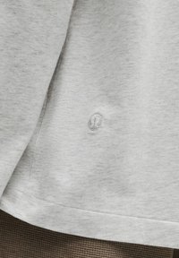 Grå bomulds t-shirt med en meleret tekstur, der har et lille broderet logo nær kanten og en afslappet pasform.