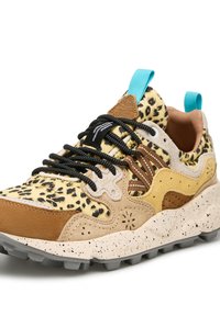 Le sneakers presentano una tomaia con stampa ghepardo gialla e nera, dettagli in suede marrone, lacci neri e una suola testurizzata color beige con spruzzate nere.