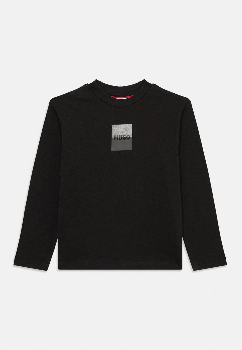 Juodas ilgomis rankovėmis marškinėliai pagaminti iš medvilnės, su kvadrato formos pilku logotipu, kuriame užrašyta "HUGO" juoda spalva. Apvalus kaklas ir minkšta tekstūra.