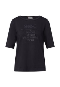 T-shirt noir à manches courtes avec un col rond, ornée de texte blanc incluant "SPRING" et d'autres phrases dans des styles de police variés.