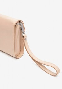 Nude patenten clutch met een polsbandje, met een gladde afwerking, rechthoekige vorm en zilveren hardwaredetails.