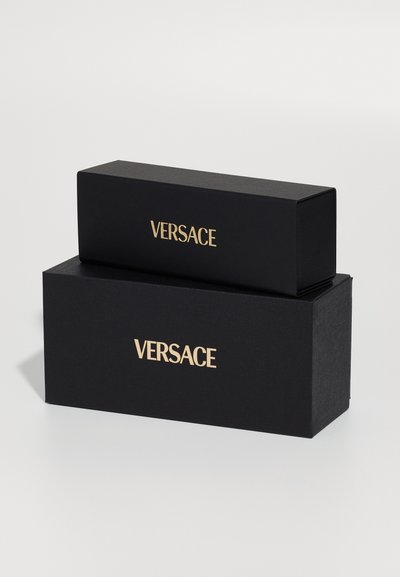 Black rectangular boxes with a textured finish, featuring gold "VERSACE" branding on the front, stacked vertically.