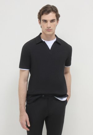 Polo nero a maniche corte con superficie texture, colletto e dettagli bianchi a contrasto sulle maniche. Design slim fit.