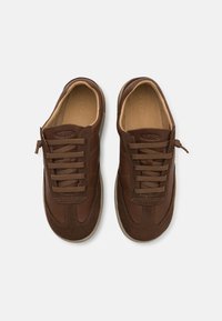Braune Leder- und Wildledersneaker verfügen über eine abgerundete Zehenform, flache Schnürsenkel und einen gepolsterten Schaft. Die Laufsohle ist aus Gummi mit einem beigen Akzent.