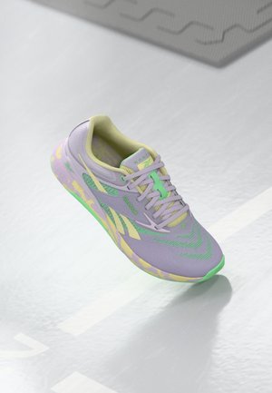 Light purple athletic shoe with green accents, patterned mesh upper, textured sole, and flat laces. Features a cushioned collar and tongue.