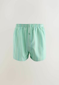 Boxers vert clair avec des rayures verticales blanches et bleues, une ceinture élastique et un seul bouton sur l'ouverture avant.