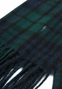 Zielono-granatowy szalik w kratę, wykonany z miękkiej wełny, z frędzlami na końcach i małym haftowanym detalem, prezentujący wzór w kratkę.