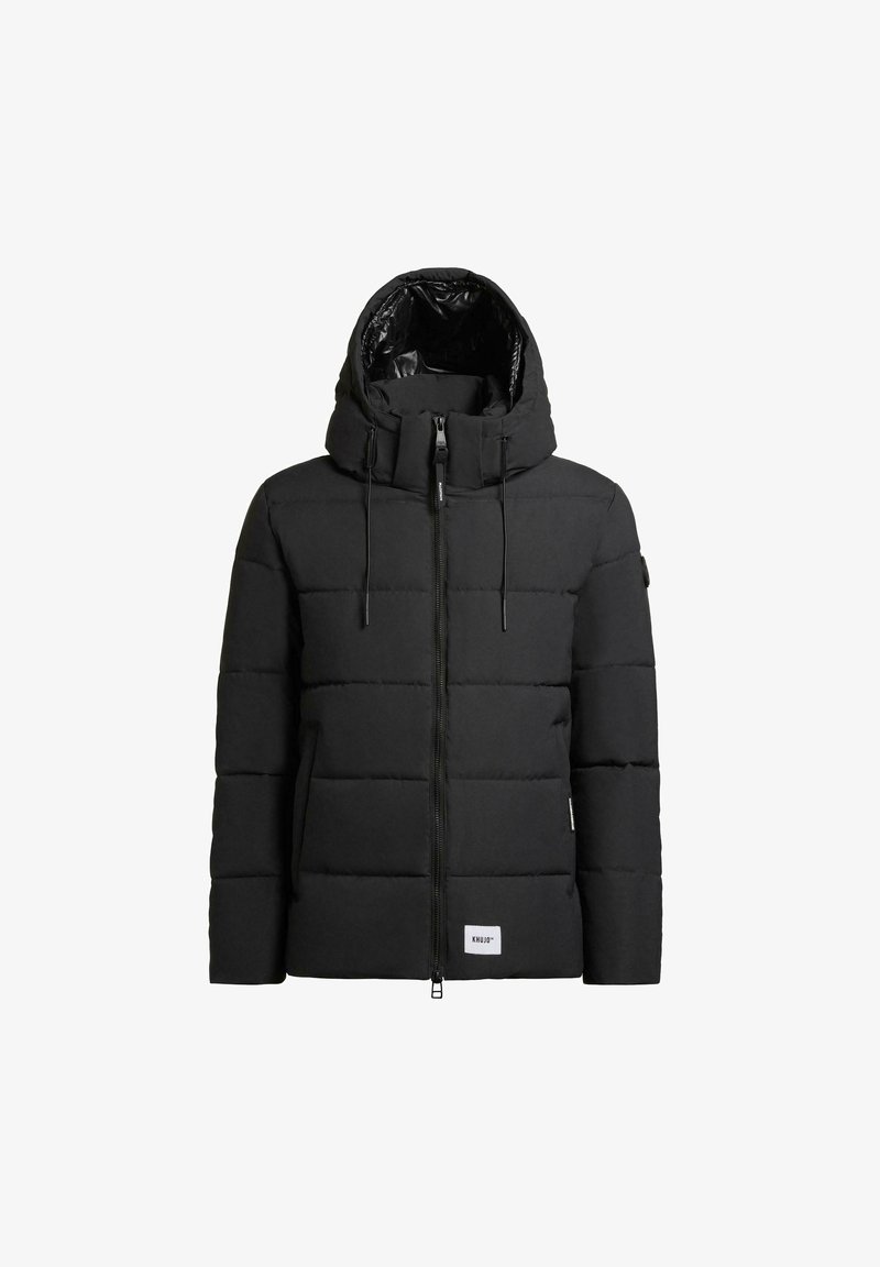 Black puffer jacket with a high collar and adjustable hood. Features a front zipper, vertical quilting, and a brand label on the lower front.