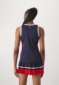 Navy athletic dress with a pleated skirt. Features red side accents and white striping. Made from a smooth, moisture-wicking fabric.