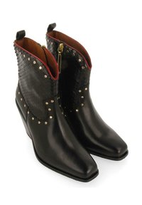 Botas de tobillo de cuero negro con un upper texturizado negro, tachuelas doradas y una cremallera. Presenta una punta afilada y un ligero tacón.