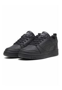 Baskets de sport noires en cuir avec des détails perforés, lacets plats et semelles en caoutchouc. Elles présentent un logo et un col rembourré pour le confort.