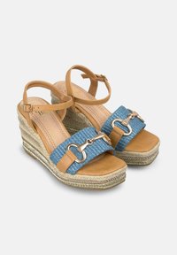 Sandali con zeppa caratterizzati da una fascia in pelle marrone e una banda intrecciata blu, accentuati da dettagli in metallo argentato e una suola in espadrille testurizzata.