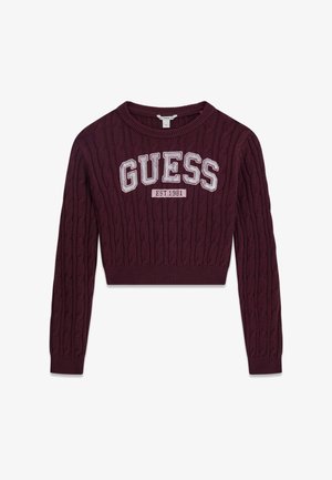 Pull court en maille torsadée violet foncé, manches longues, avec "GUESS EST. 1981" brodé en grandes lettres blanches sur la poitrine.