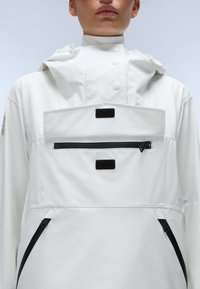 White pullover jacket featuring a high collar, adjustable hood, and front zip pocket with black accents and velcro closures. Smooth texture.
