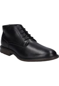 Botas de cuero negro hasta el tobillo con un diseño de cordones, punta redondeada, acentos cosidos y una suela de goma marrón. Textura suave con acabado pulido.