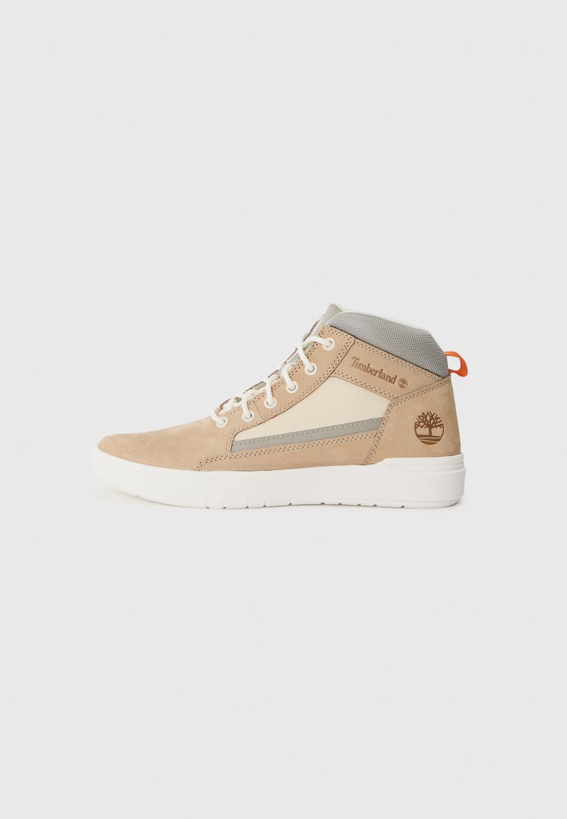 Beige suède high-top sneaker met een grijze mesh kraag, witte rubberen zool en Timberland-logo. Heeft crèmekleurige accenten en een vetersluiting.