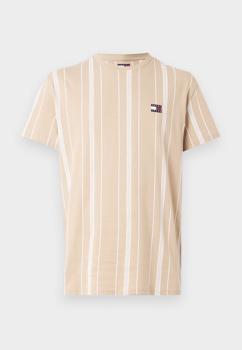 Beżowy t-shirt z krótkim rękawem w pionowe białe paski, z małą naszywką z logo Tommy Jeans po lewej stronie klatki piersiowej.