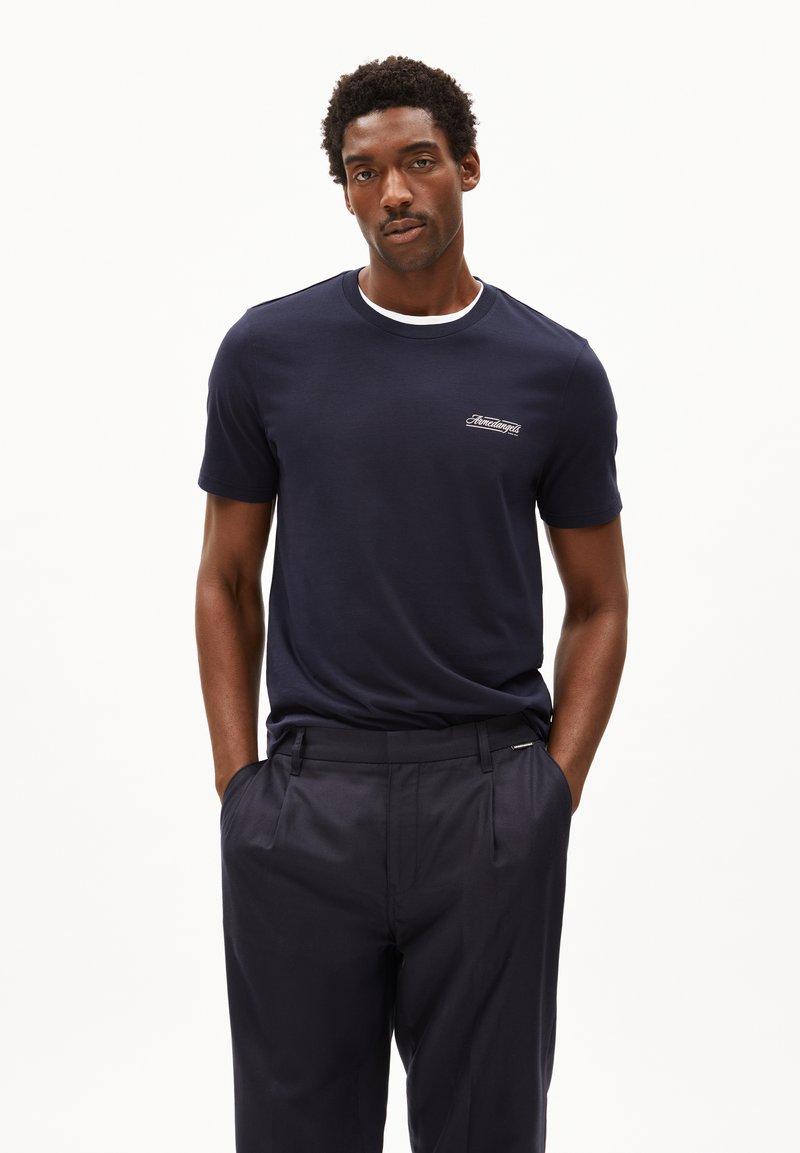 Marineblauwe T-shirt met korte mouwen, voorzien van een witte ronde hals en een klein geborduurd logo op de borst. Glad katoen, relaxed fit.