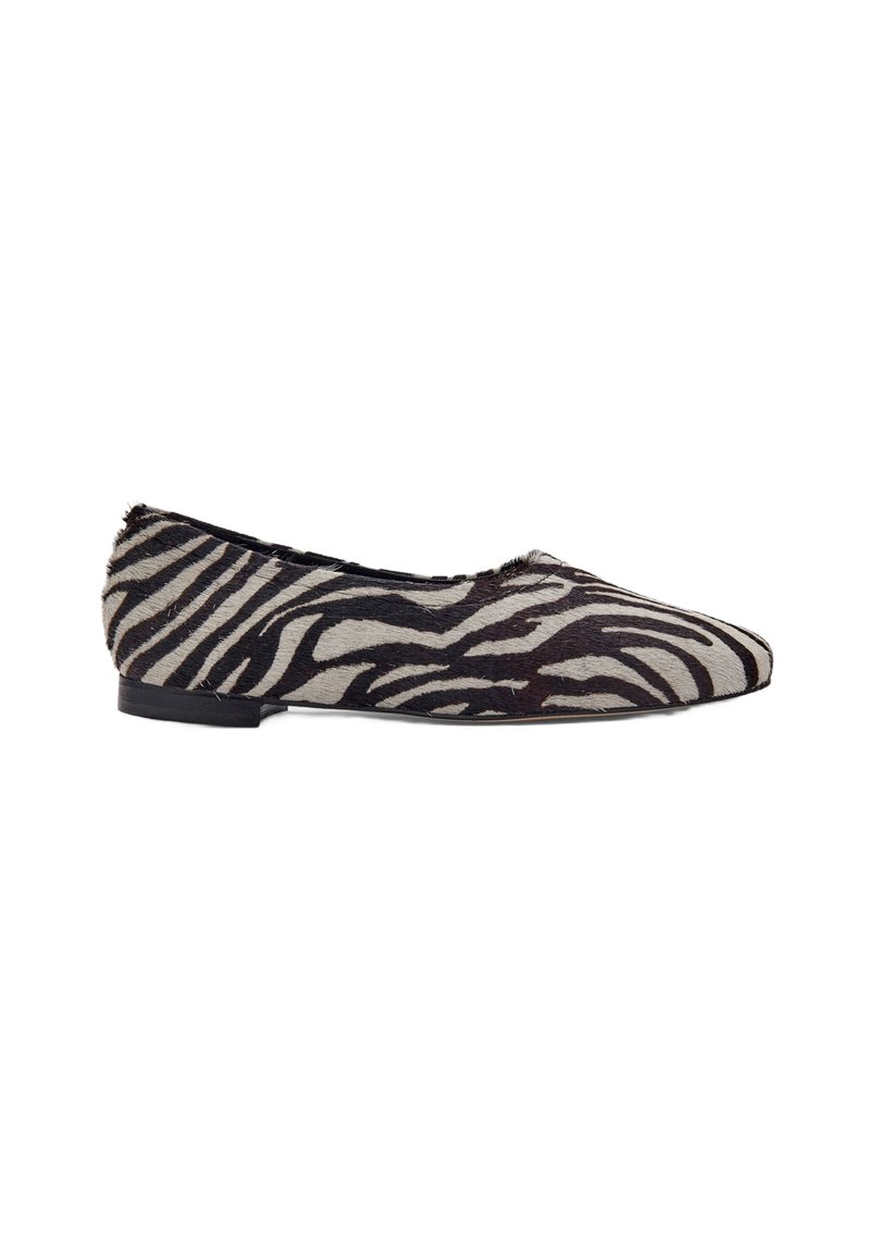 Platte schoen met zwart-wit zebra printpatroon en spitse neus, lage hak, zijaanzicht op een witte achtergrond.