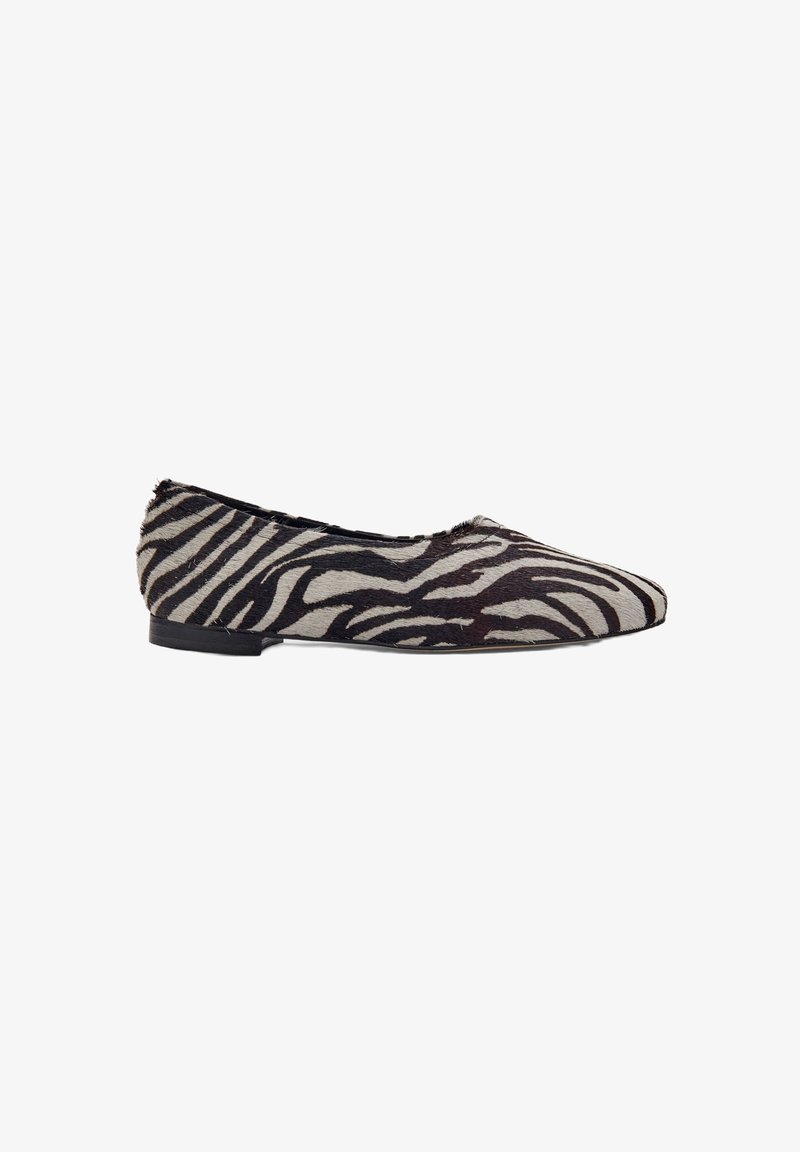Platte schoen met zwart-wit zebra printpatroon en spitse neus, lage hak, zijaanzicht op een witte achtergrond.