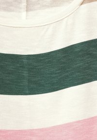 Närbild av stickat tyg med horisontella ränder i kräm, mörkgrön och rosa färger.