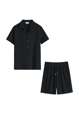 Ensemble en noir comprenant un haut à manches courtes côtelées et un short, avec un col, une fermeture à boutons et une taille élastique avec cordon de serrage.