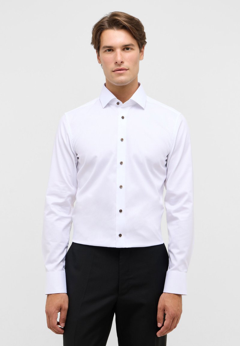 Witte button-down blouse met een klassieke kraag en bruine knopen, voorzien van lange mouwen en een gladde, gestructureerde stof.