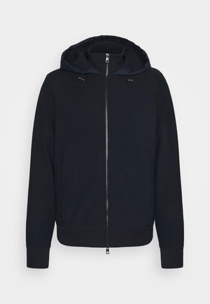 Sweat à capuche zippé bleu marine en matière douce, avec capuche à cordon, fermeture éclair à l'avant, poignets et ourlet côtelés. Aucun motif notable.