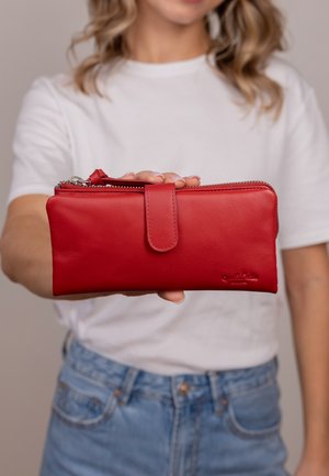 Rote Lederbrieftasche mit glatter Textur, Reißverschluss und passendem Druckknopfverschluss. Logo seitlich geprägt.