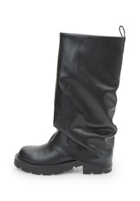 Stivale in pelle nero a metà polpaccio con punta arrotondata, suola bassa e corposa, e linguetta sul retro, presentato di profilo su sfondo bianco.