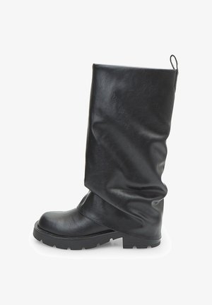 Stivale in pelle nero a metà polpaccio con punta arrotondata, suola bassa e corposa, e linguetta sul retro, presentato di profilo su sfondo bianco.